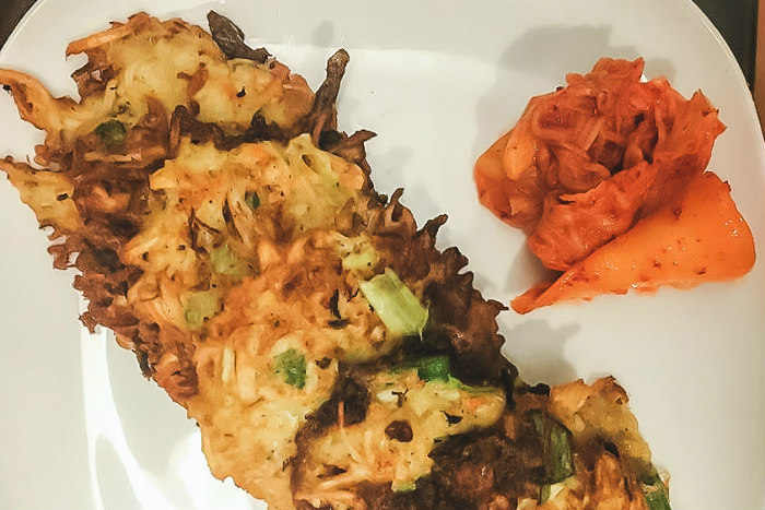 Potato latkes with kimchi on a white plate 